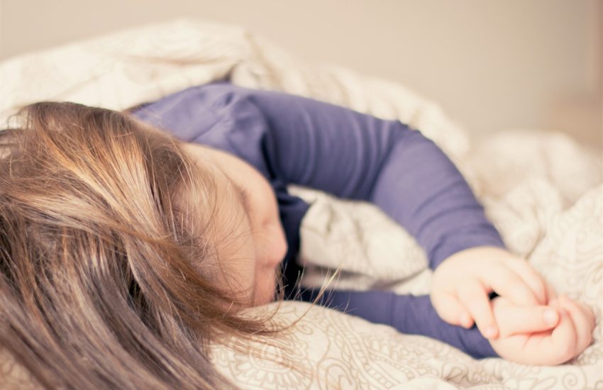 Kind beim Schlafen im Bett